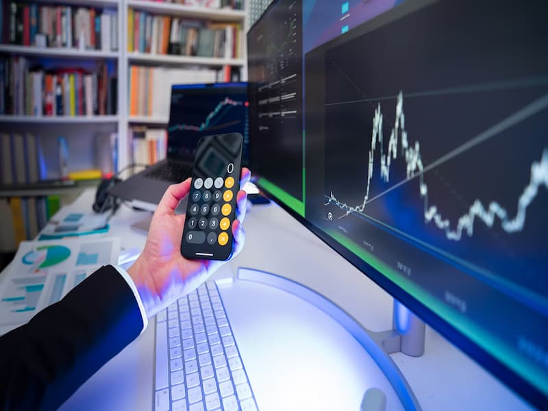 A imagem mostra um ambiente de trabalho moderno e tecnológico, com foco em análises financeiras e uso de dados, ideal para ilustrar o tema